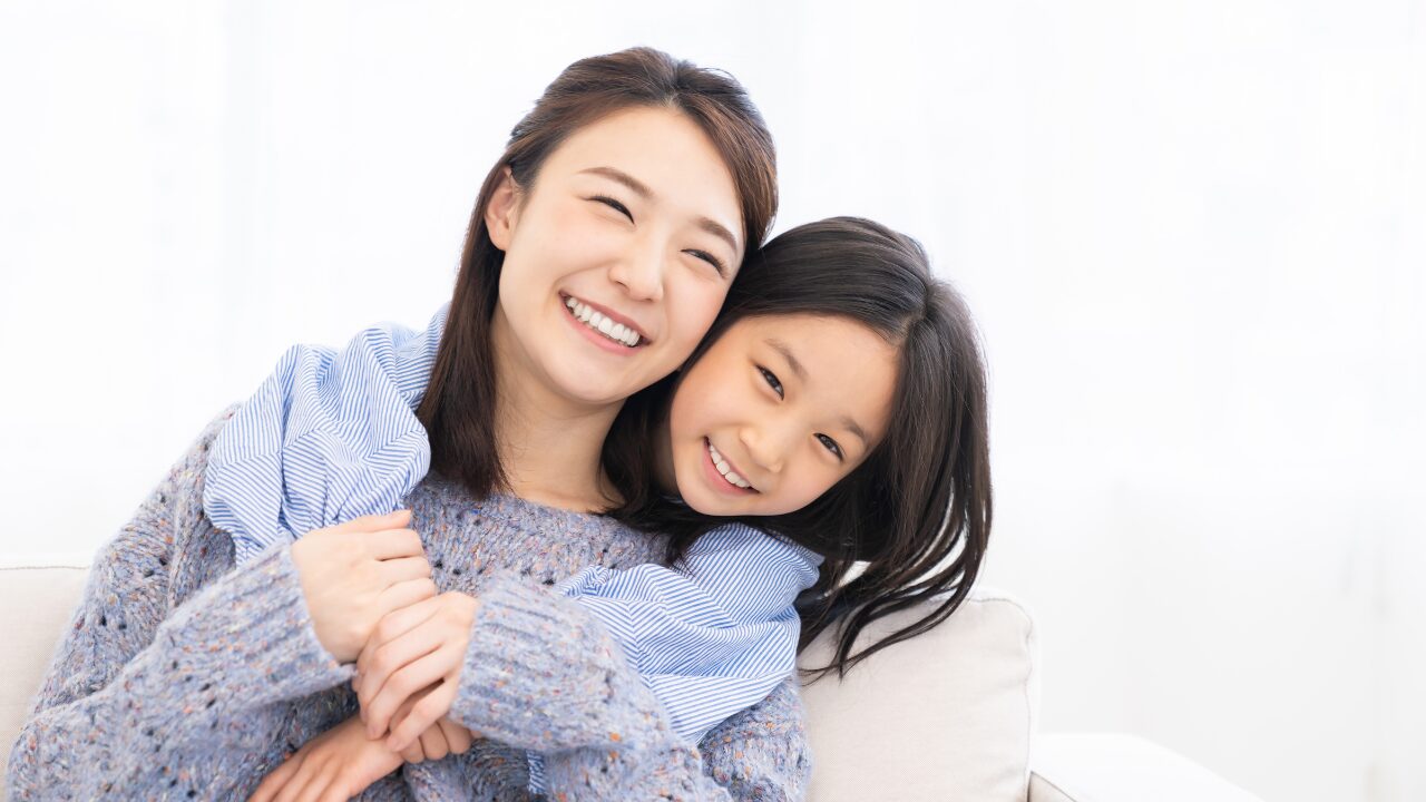笑顔で寄り添う親子の写真